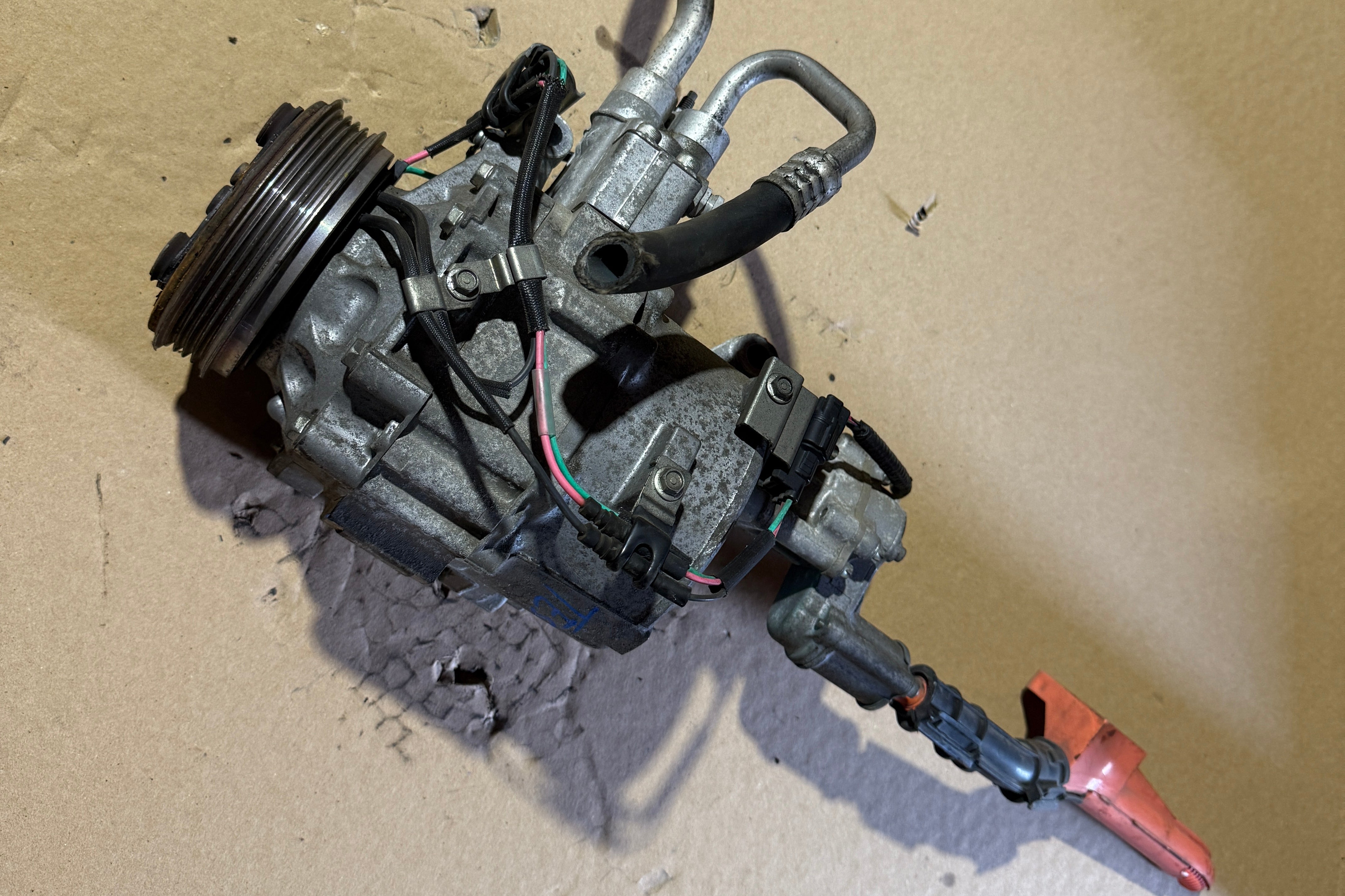 Honda Civic 1.3L Hybrid AC Compressor Angle near the wires, showing two wires going in the clutch and one pink wire and green wire going to the bottom sensor.